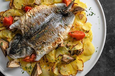Сибас, запеченный с картофелем и овощами