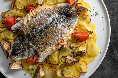 Запеченная дорадо с картофелем и овощами