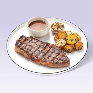 Стейк стриплойн с картофелем стоун, печёным чесноком и соусом карамелизованный лук