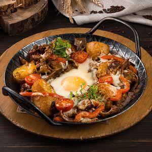 Сковородка с языком, ушами и жареным яйцом