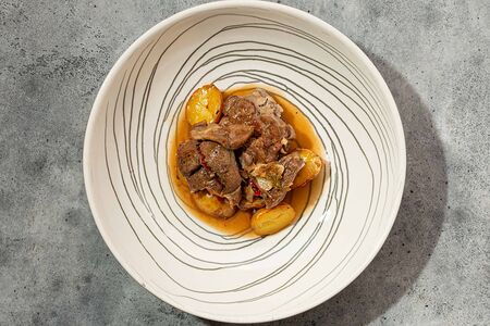 Трехнедельный козленок, томленный с картофелем и травами