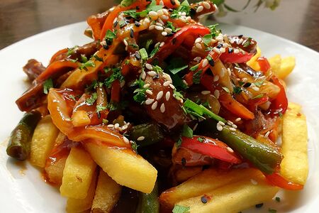 Картофель фри с мясом и овощами в соусе