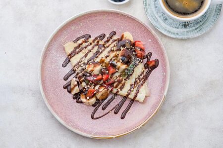 Блинчики с шоколадной пастой, бананом и ягодами