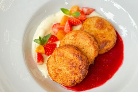 Сырники с клубничным соусом и сметанным кремом 