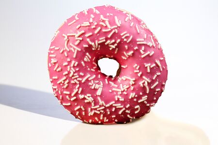 Пончик-донат с розовой глазурью и посыпкой из белого шоколада