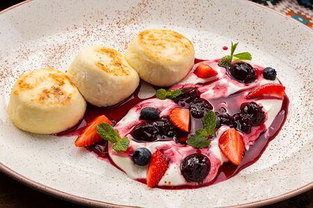 Сырники с ягодами и сметаной