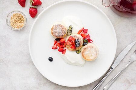 Сырники со сметаной и сезонными ягодами