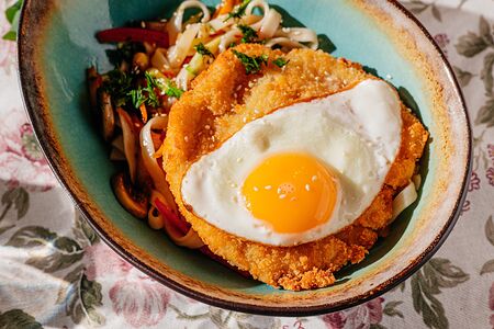 Шницель из цыпленка с лапшой удон и жареным яйцом