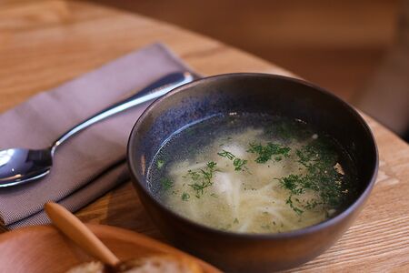 Куриный бульон с домашней лапшой, филе бедра и перепелиным яйцом 