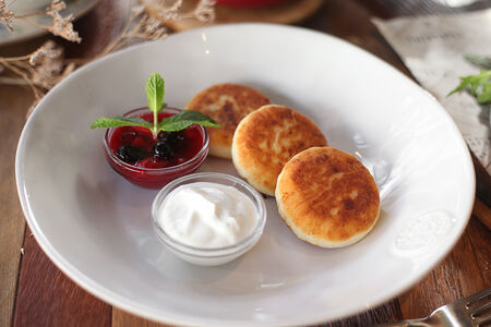 Сырники из рикотты со сметаной и вареньем