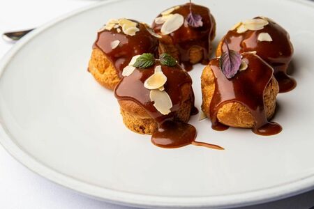 Профитроли с ванильным кремом под карамельным соусом