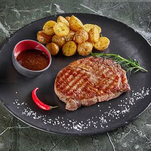 Рибай стейк с молодым картофелем и перечным соусом