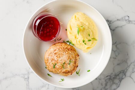 Куриная котлета с пюре и брусничным соусом