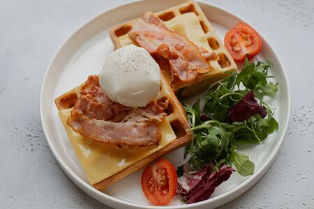 Вафли с поджаренным беконом, сыром чеддер, яйцом пашот