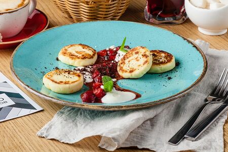 Сырники с ягодным соусом и сметаной