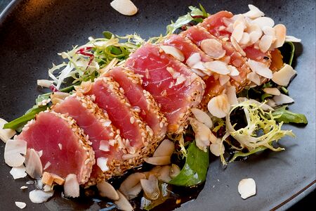 Тунец в кунжуте с миндальными лепестками на подушке из салатного микса