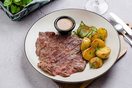 Стейк мясника с перечным соусом, картофелем бейби и огурцами бурбон