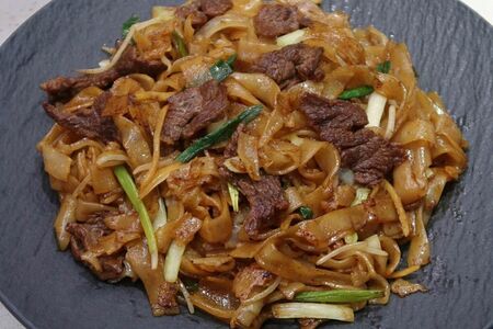 Жареная рисовая лапша с говядиной и овощами