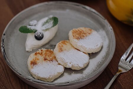 Сырники со сметанным соусом и свежей черникой