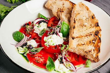 Розовые томаты с сыром страчателла и красным луком