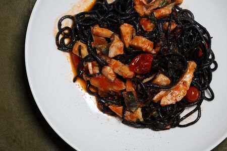 Черные спагетти с сибасом и томатами