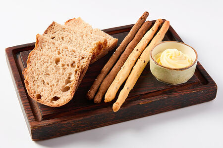 Серый хлеб с гриссини и сливочным маслом