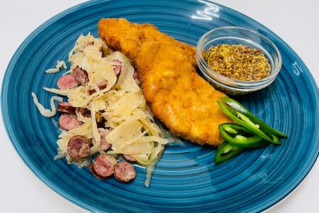 Шницель cвинoй с тушеной капустой и копченными колбасками