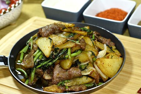 Острая говядина с картофелем на горячей сковороде