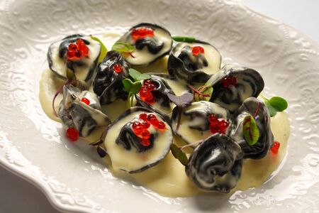 Черные пельмени с белой рыбой