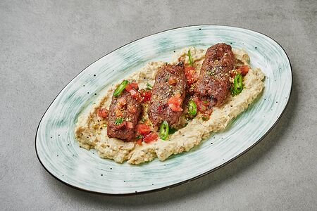 Кебаб из баранины на подушке из печеных баклажанов с соусом мацони