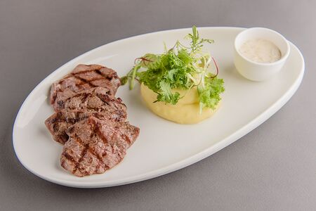 Медальоны из телячьей вырезки, приготовленные на углях с соусом из белых грибов