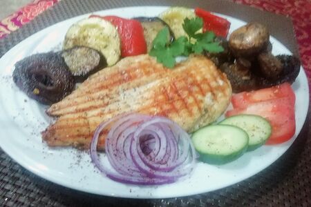 Стейк из куриной грудки, с овощами (огурцы, помидоры), лук маринованный, соус