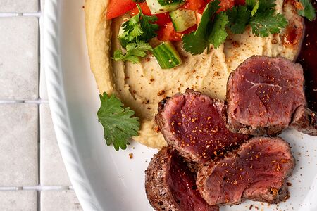 Говядина на хумусе с соусом из красного вина и пряных трав