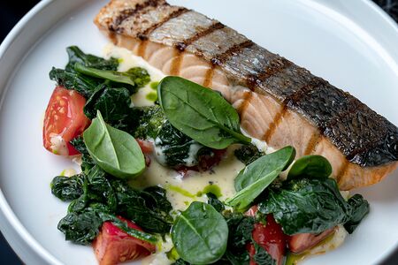 Стейк из лосося с томатами, шпинатом и жжеными сливками