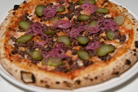 Пицца-бургер с томатным соусом, сыром, маринованными огурчиками и мясом