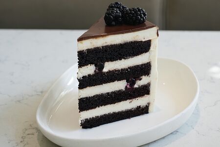 Кусочек шоколадно-ванильного торта с ежевикой