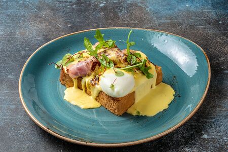 Бриошь с яйцом пашот, жареным беконом и соусом голландез