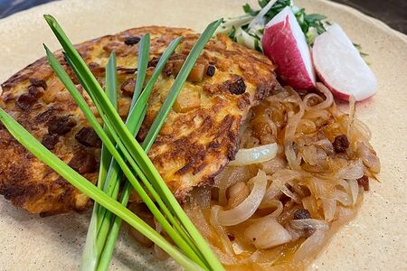 Драник с молодой телятиной на луковой подушечке со шкварками