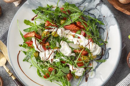 Салат со страчателлой, рукколой, розовыми томатами и оливками