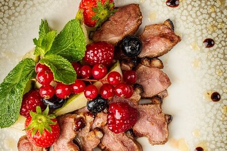 Подкопченая утиная грудка, запеченая в медовом соусе с ягодами малины, ежевики, клубники и винoградом