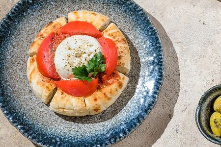 Буррата на узбекской лепешке с томатами, матбухой и зеленым маслом