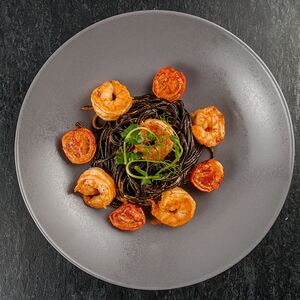 Черные спагетти с креветками и соусом термидор
