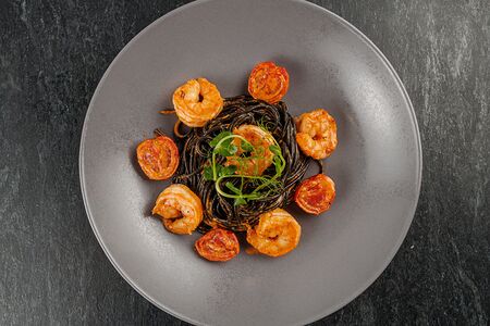 Черные спагетти с креветками и соусом термидор