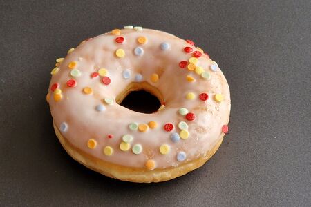 Донат с ванильной глазурью, с радужной посыпкой, без начинки