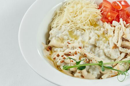 Каша с пармезаном, куриные филе, соусом цезарь и томатами