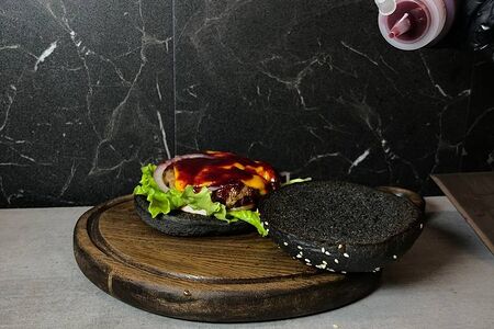 Черный бургер с говяжьей котлетой и брусничным соусом