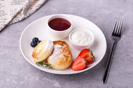 Сырники с ягодами, сметаной и джемом