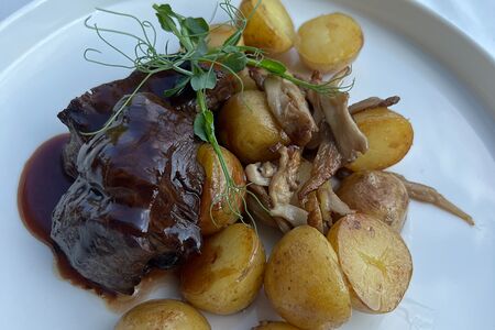 Стейк из телятины с винным соусом, молодым картофелем и вешенками
