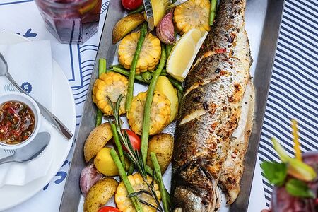 Сибас со спаржей, картофельными дольками, кукурузой и томатами черри