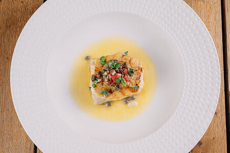 Сибас с хрустящим картофелем под соусом из каперсов